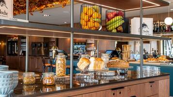 Un espace buffet proposant divers plats et un bar en arrière-plan.