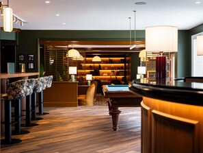 A modern hotel lobby with a pool table, bar area, and seating. - Mercure Omaha Beach Hotel (Port-en-Bessin-Huppain)