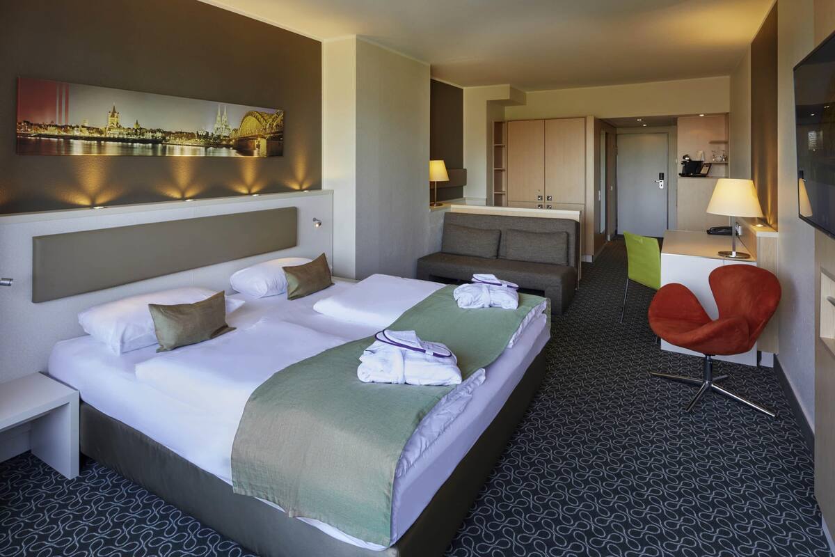 Een hotelkamer met een groot bed, een bank, een bureau en een stoel.