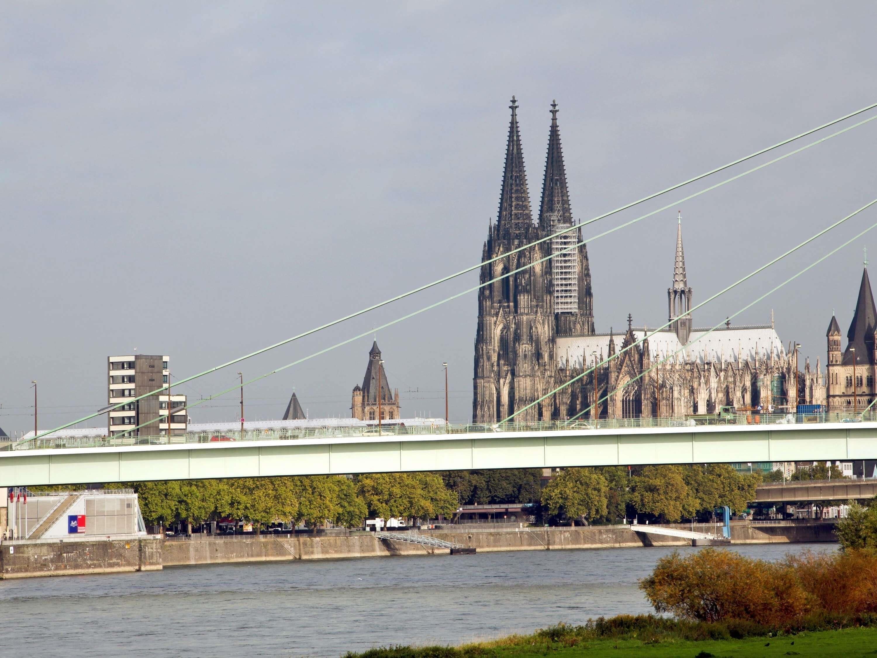 A bridge spanning a river with a historic cathedral in the background.