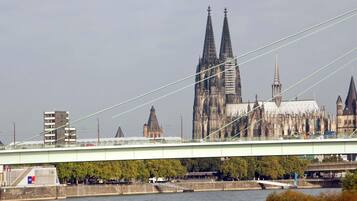 A bridge spanning a river with a historic cathedral in the background.