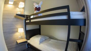 A bunk bed room with a wooden headboard, bedside lamps, and a decorative bunny figure.