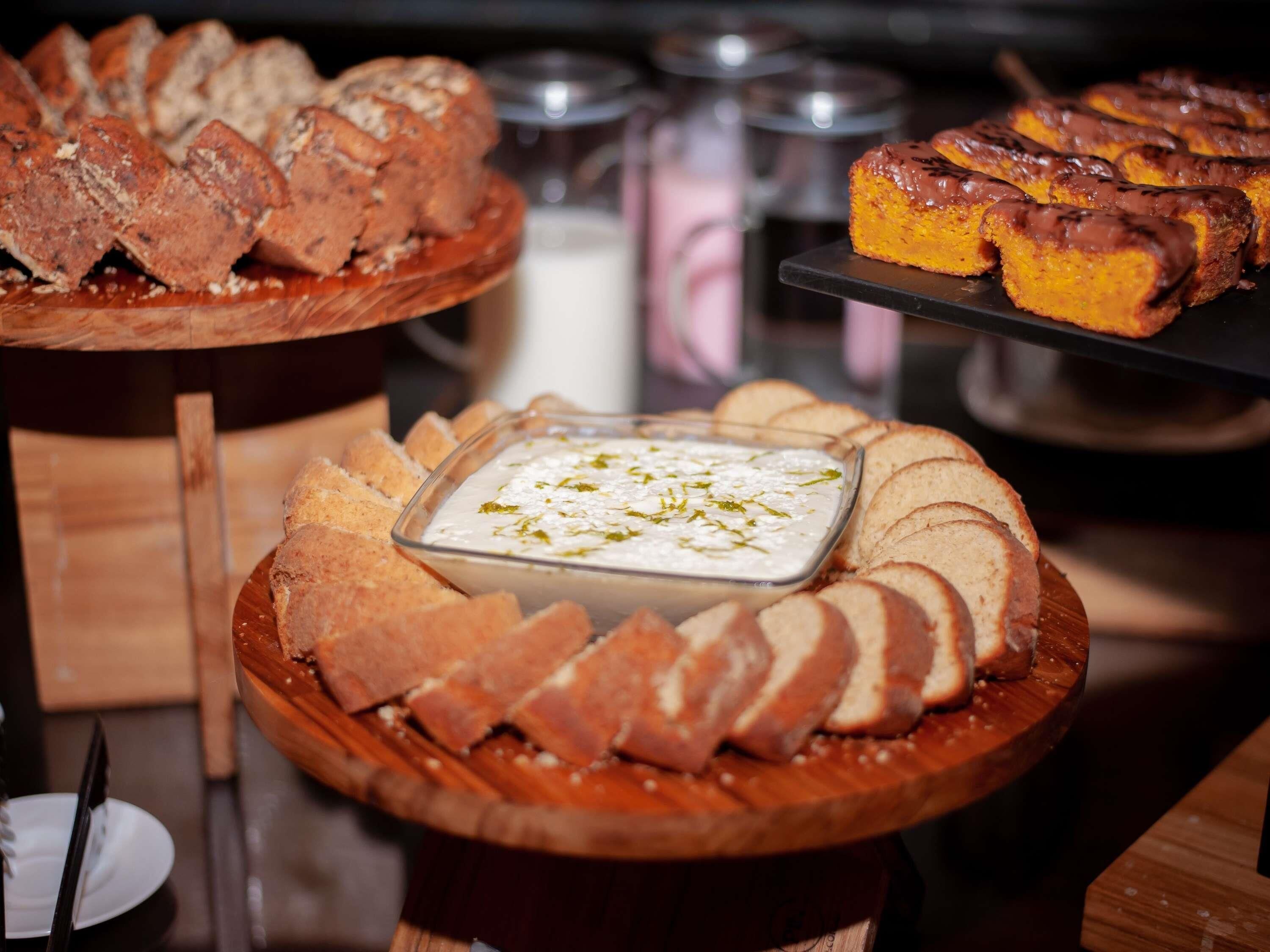 Ein reichhaltiges Buffet mit verschiedenen Speisen, darunter Brot, eine Soße und ein Dessert.