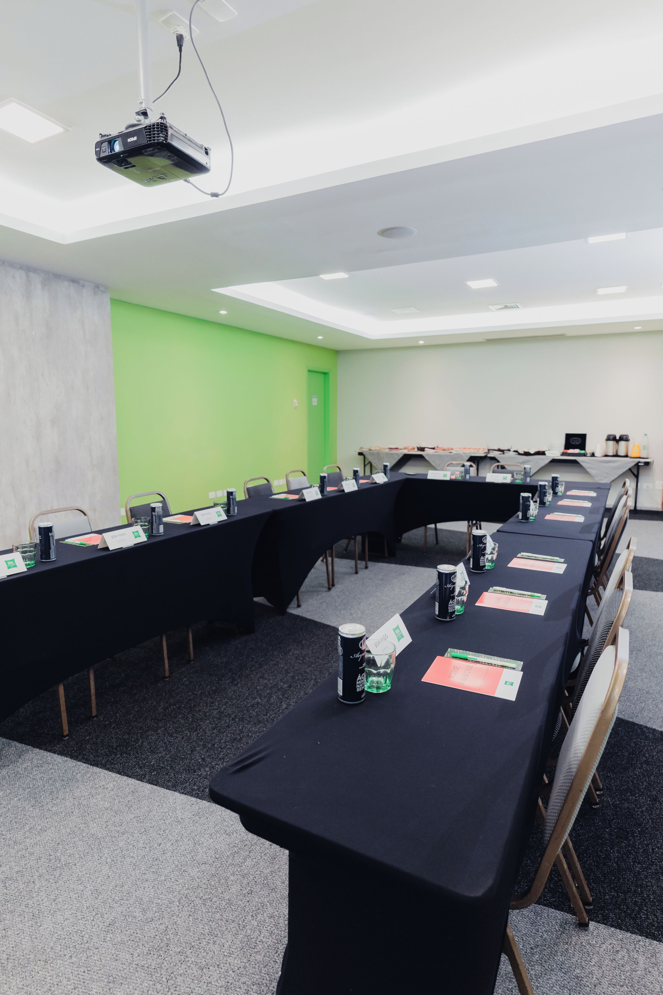 A conference room with a long table, name cards, and a projector.