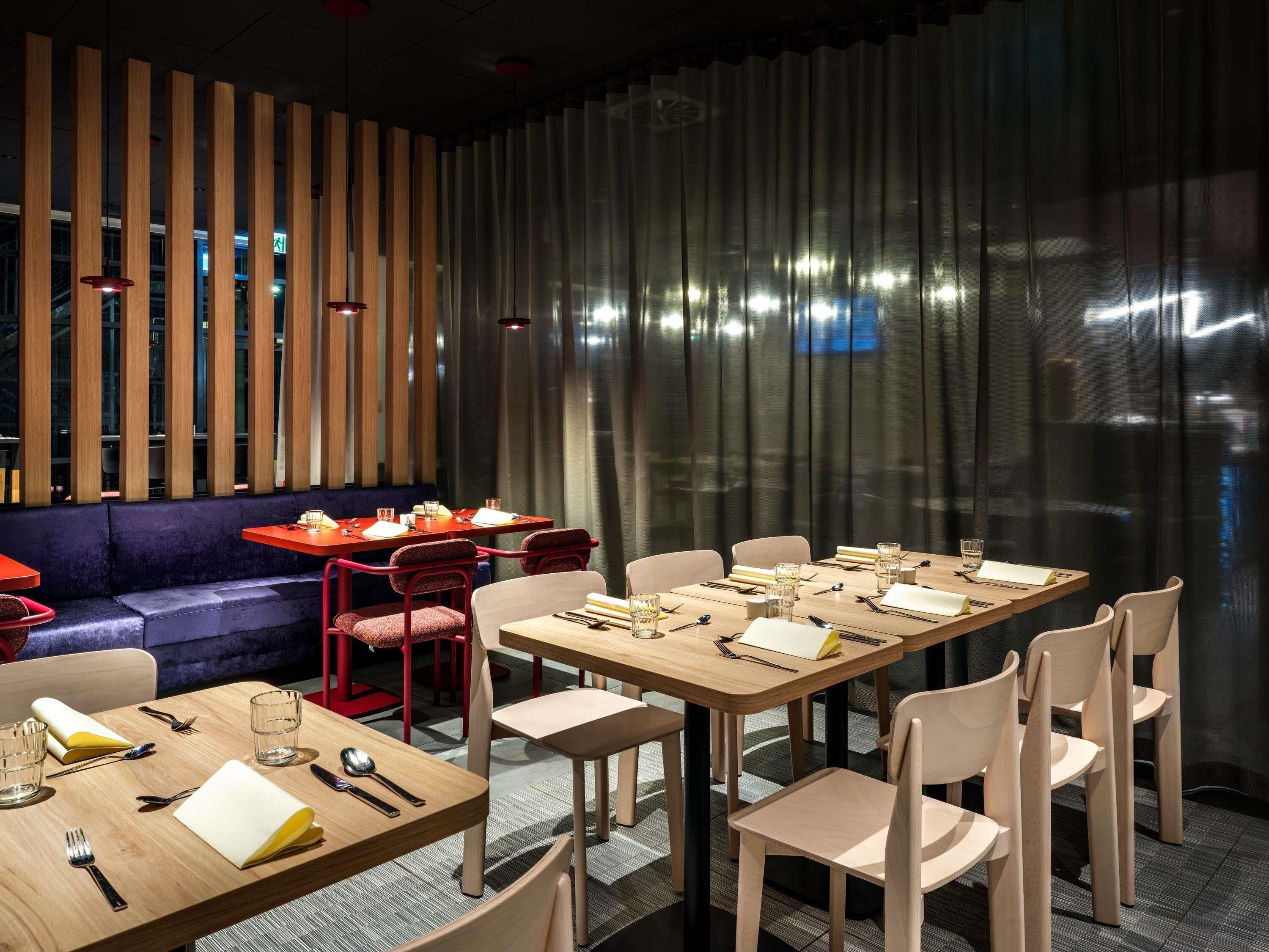 Un espace de repas moderne avec une longue table, plusieurs chaises et un canapé.