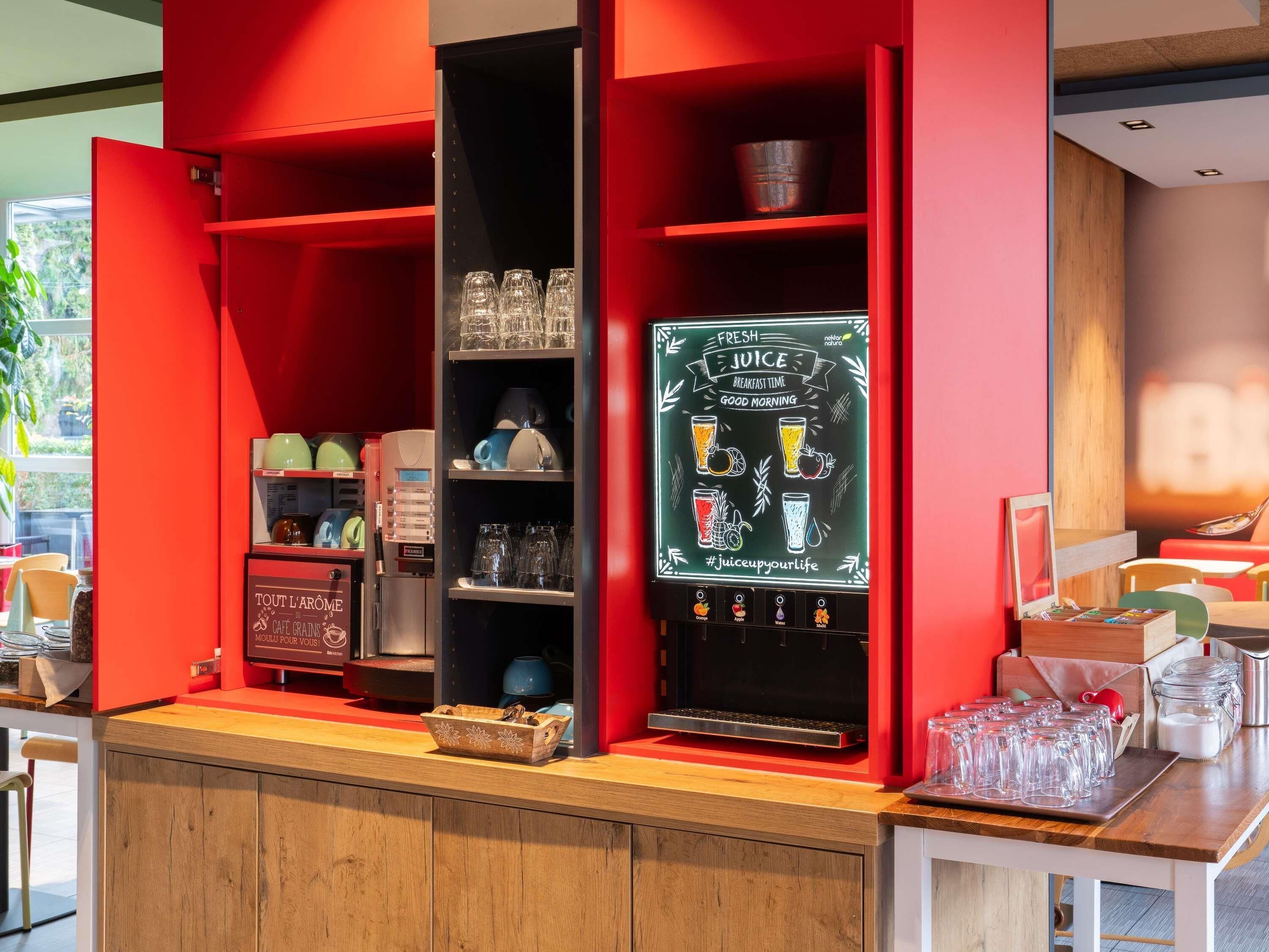 A café with a red interior, a coffee machine, and a chalkboard menu.
