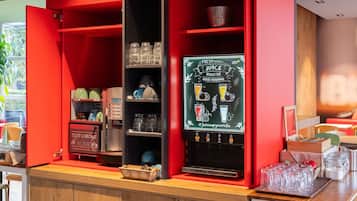 A café with a red interior, a coffee machine, and a chalkboard menu.