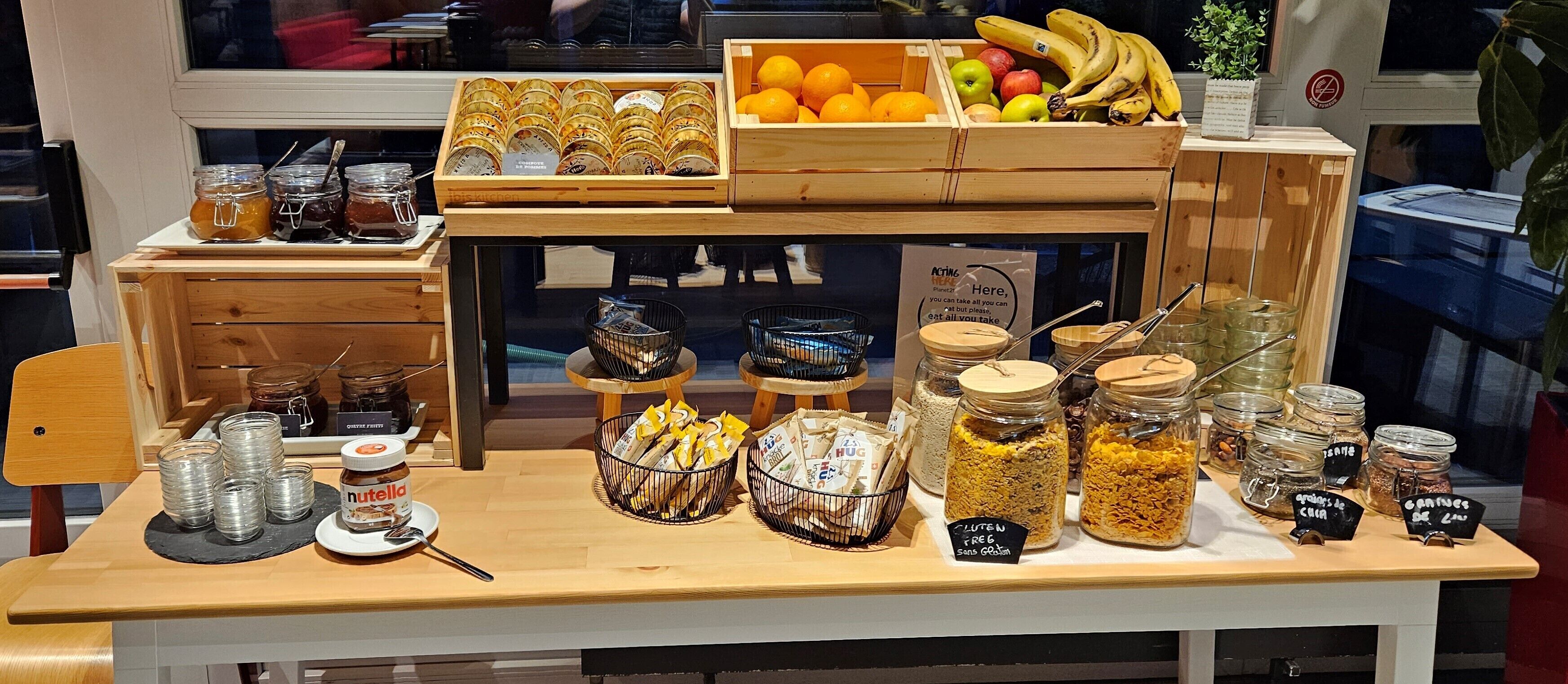 A display of food items including jars of honey, jars of nuts, and a variety of fruits and snacks.
