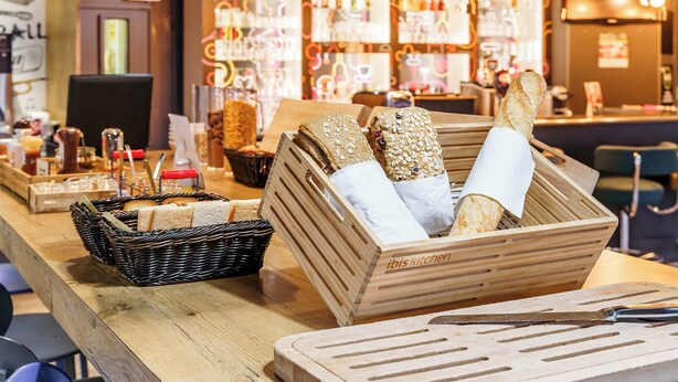 Una encimera de madera con cestas de pan y una tabla de cortar.