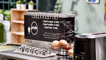 A kitchen counter with a cooking guide, a wire rack with eggs, and a stove.