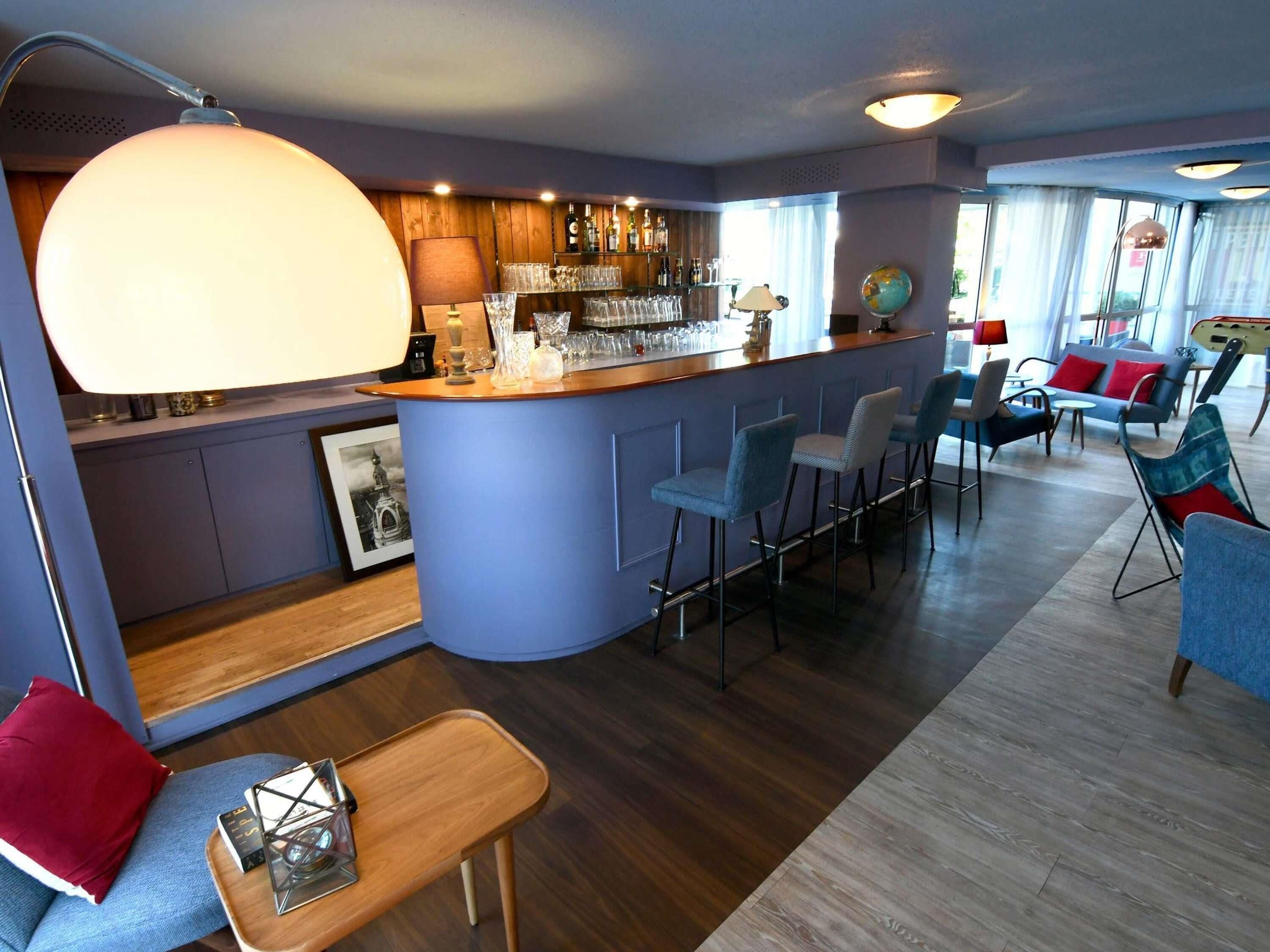 A bar area with stools, a bar counter, and a globe on the wall.