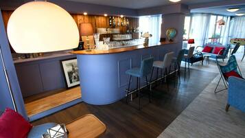 A bar area with stools, a bar counter, and a globe on the wall.