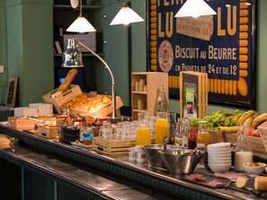 Un mostrador de buffet con diversos alimentos, bebidas y un cartel que anuncia galletas y mantequilla.
