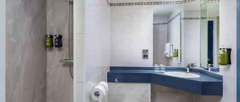 A modern bathroom with a shower, toilet, and sink.