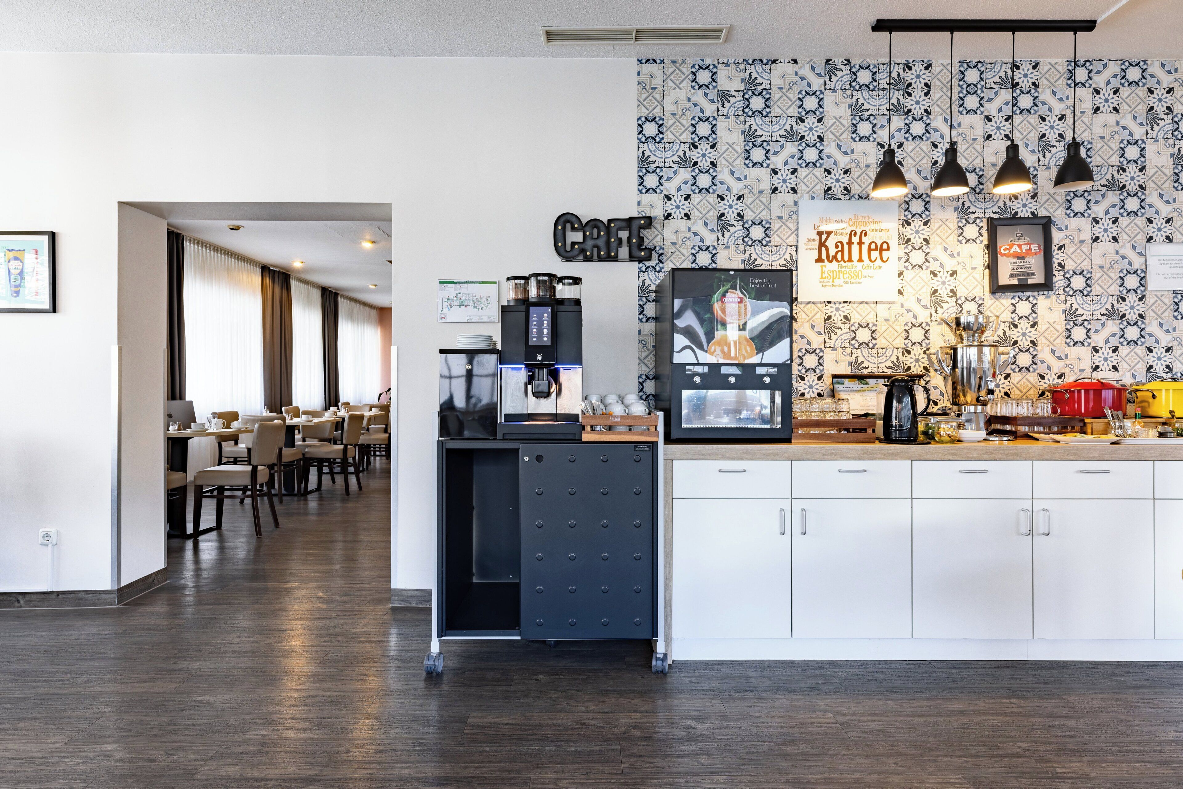 A modern cafe with a coffee machine, a menu board, and a patterned wall.