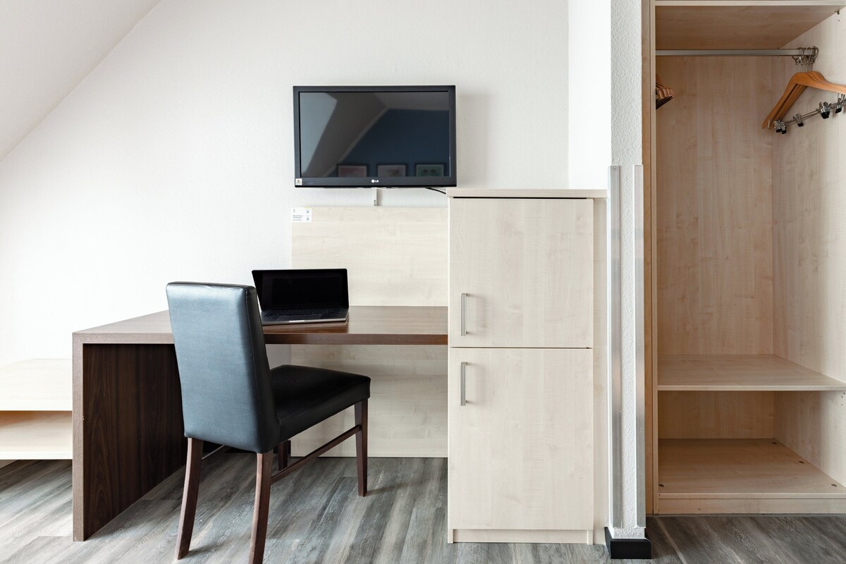 Una habitación moderna con escritorio, silla y televisor.