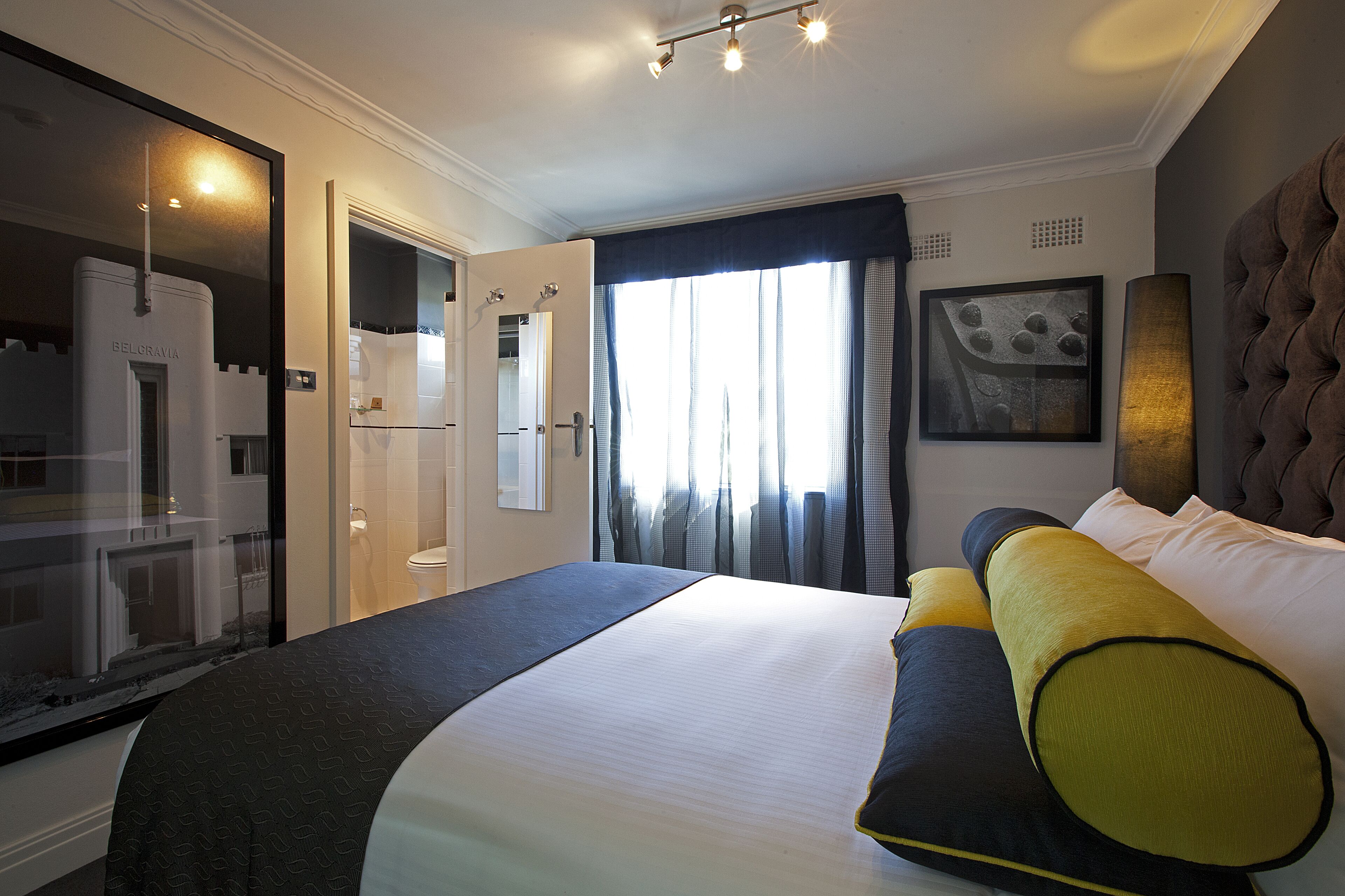 Habitación de hotel con una cama grande, armario, baño y vistas al exterior.