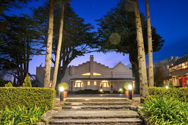 A grand building with a symmetrical facade, large windows, and a central entrance with steps leading up to it. - The Hydro Majestic Hotel (Medlow Bath)