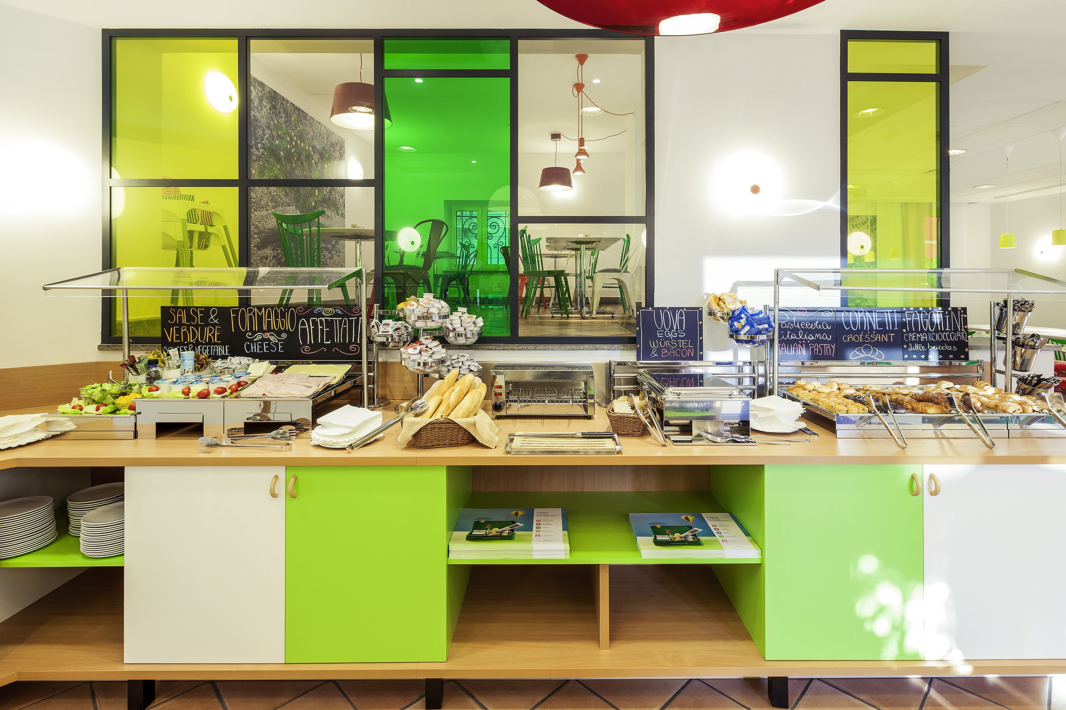 A breakfast buffet with various food items and a green and white color scheme.