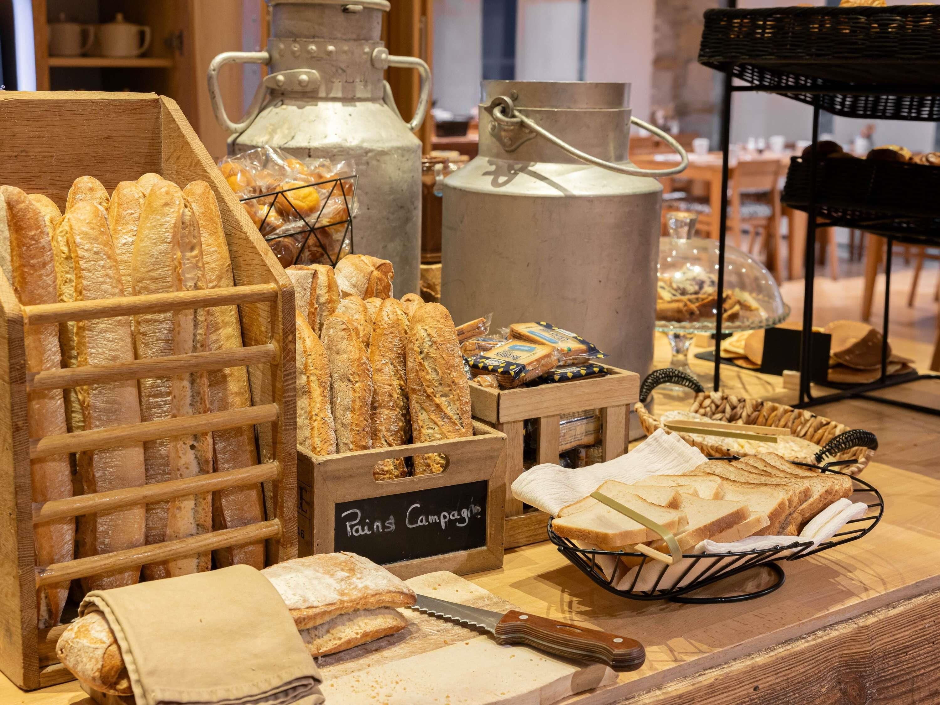 A bakery display with baguettes, bread rolls, and a sign reading 'Pain's Campaign.'