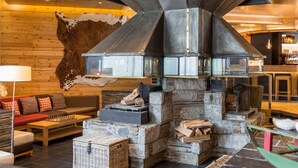 Un interior acogedor con chimenea de piedra, paredes de madera y un tapiz de cuero.