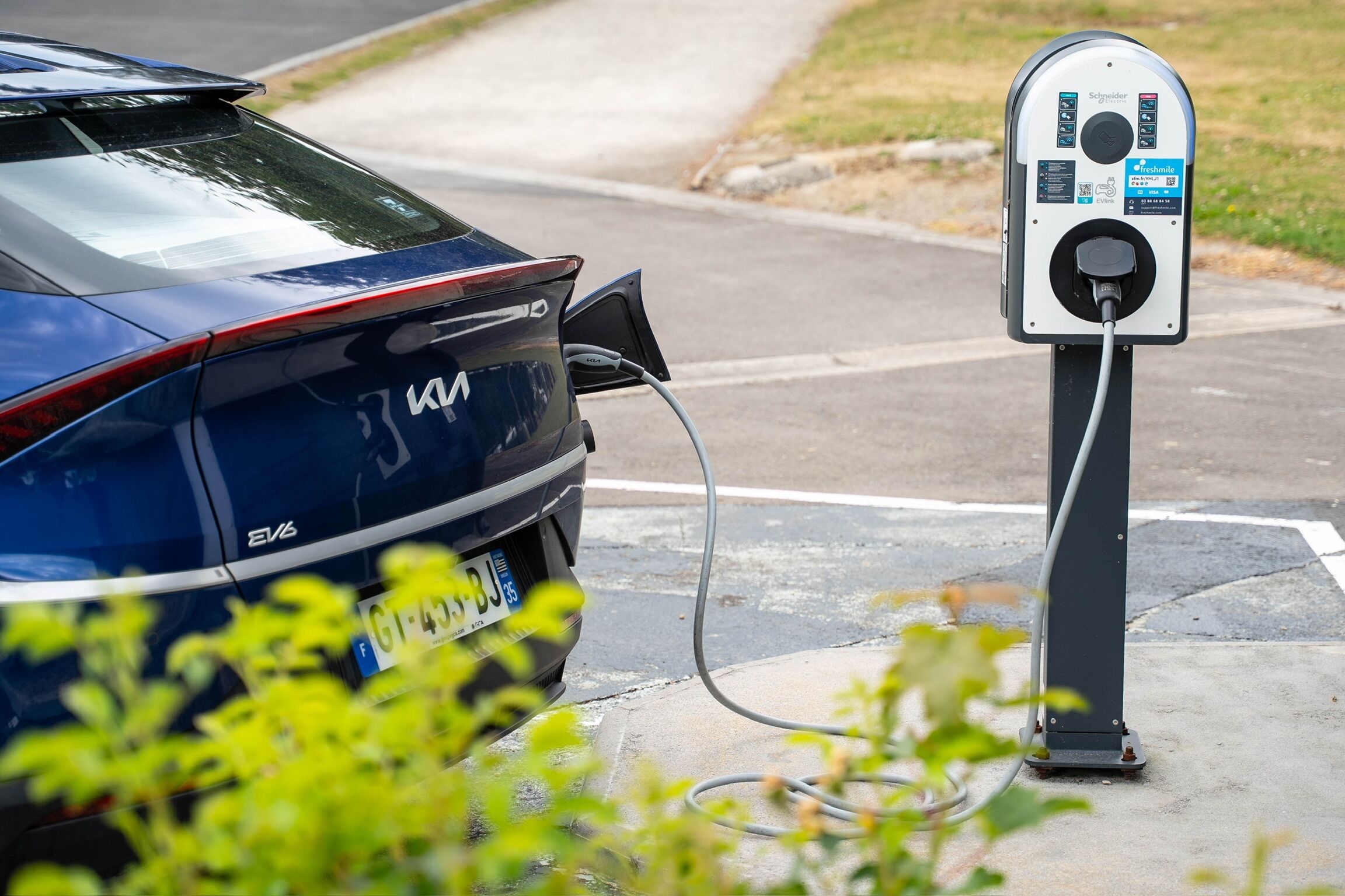 A car charging at a public EV charging station.