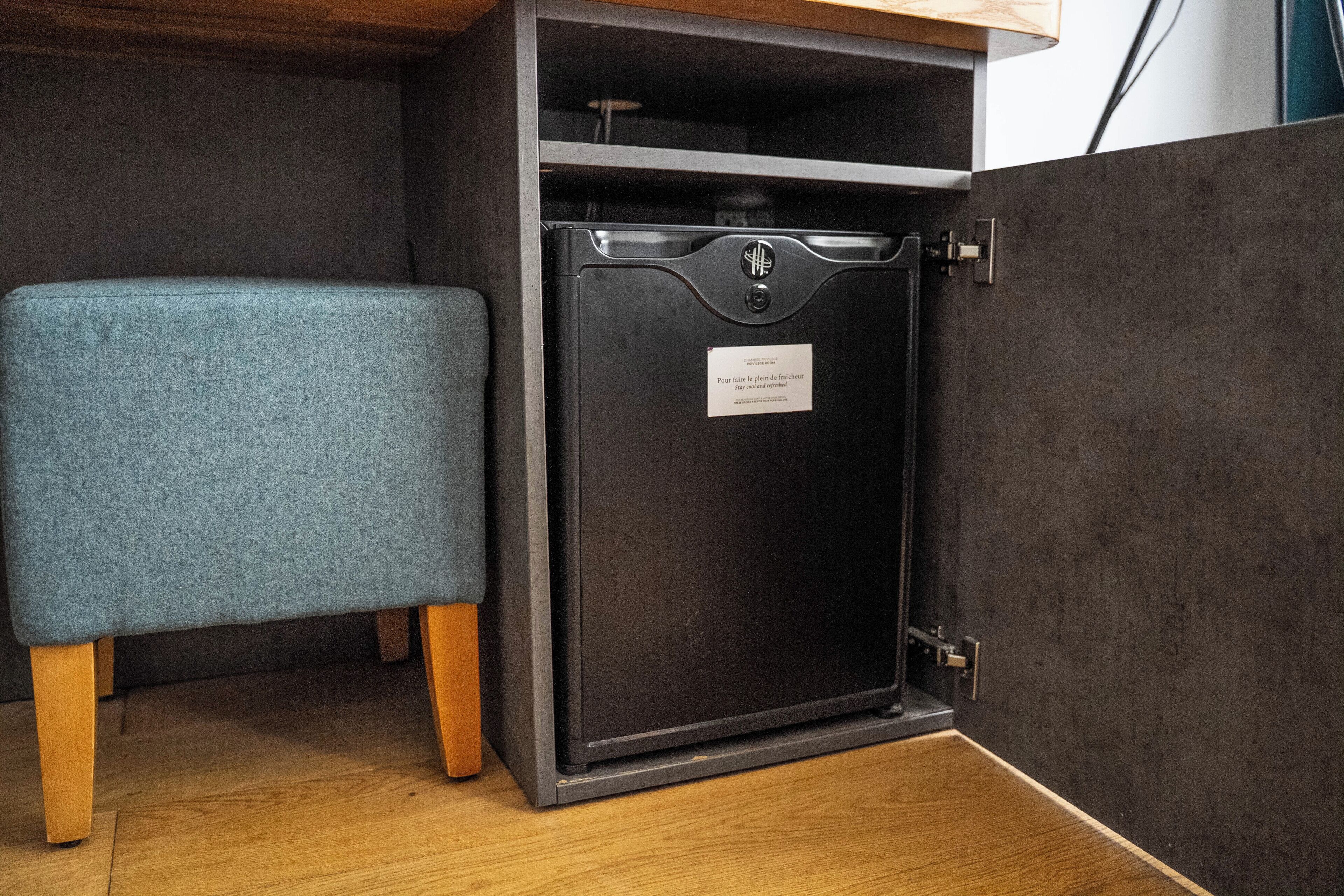 A small, dark-colored safe with a metal latch and a label that reads 'Stay cool and refreshed.'