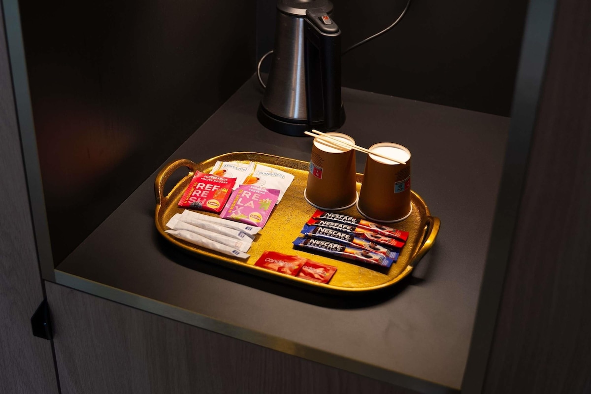Un plateau contenant des aliments et une machine à café, posés sur une table.