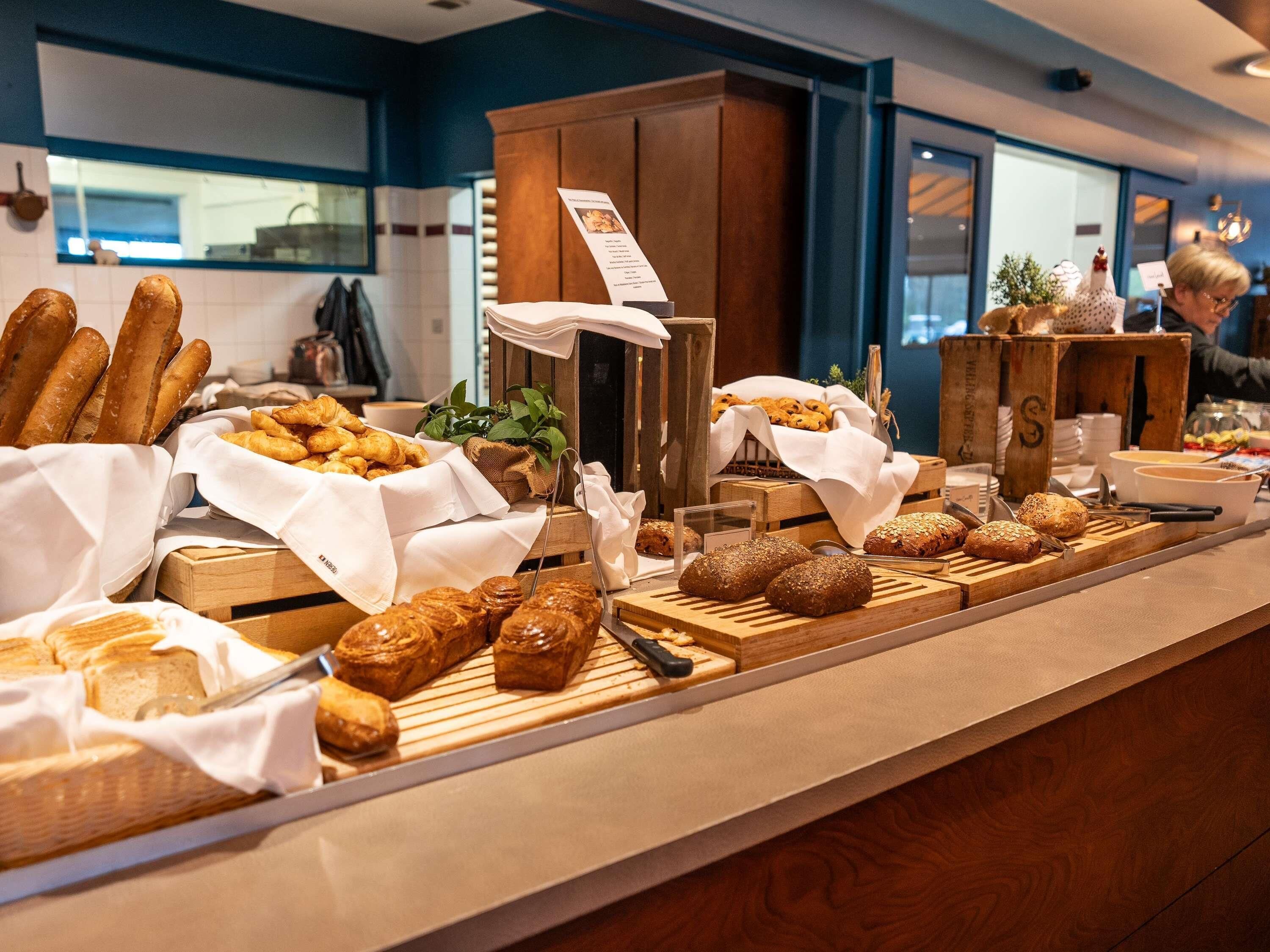 A buffet with various breads and pastries.