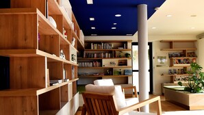 Une bibliothèque moderne avec des étagères en bois, un fauteuil à bascule et un plafond incurvé.