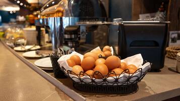 A breakfast buffet with eggs, utensils, and a coffee machine.