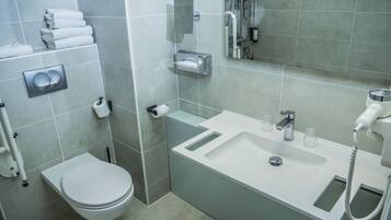 A modern bathroom with a toilet, sink, and shower.