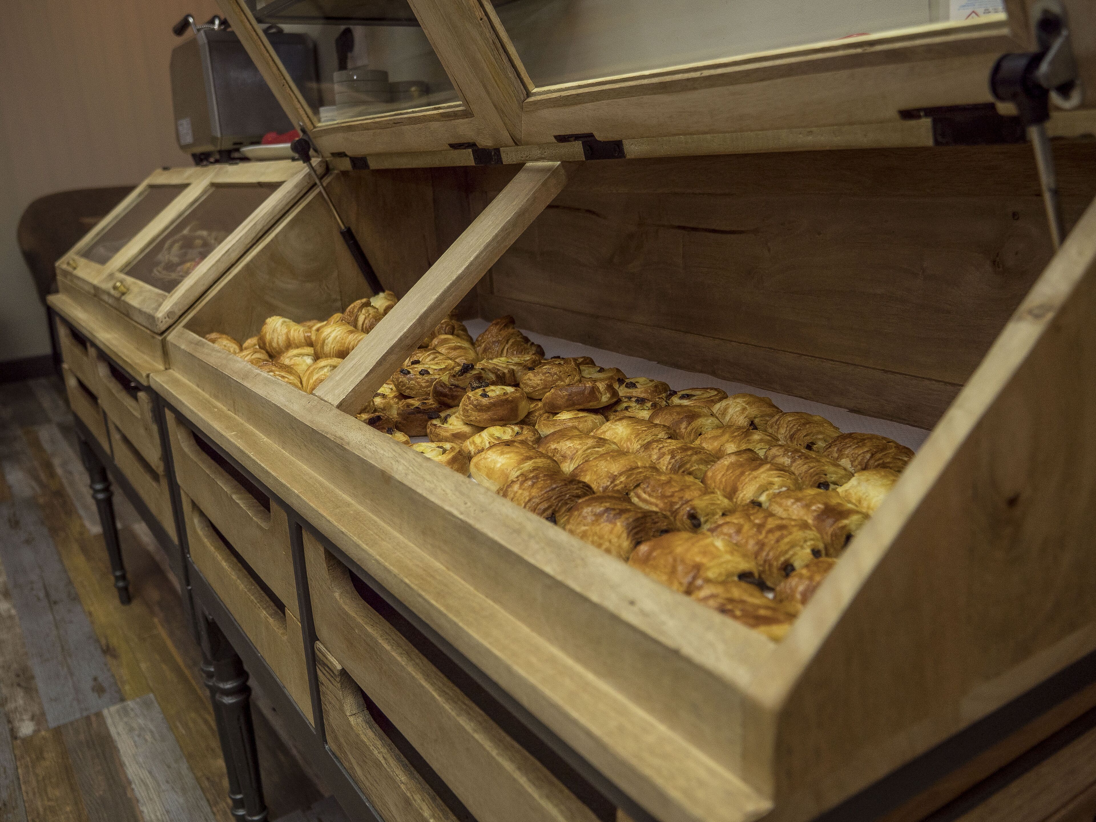 A wooden display case filled with assorted pastries.