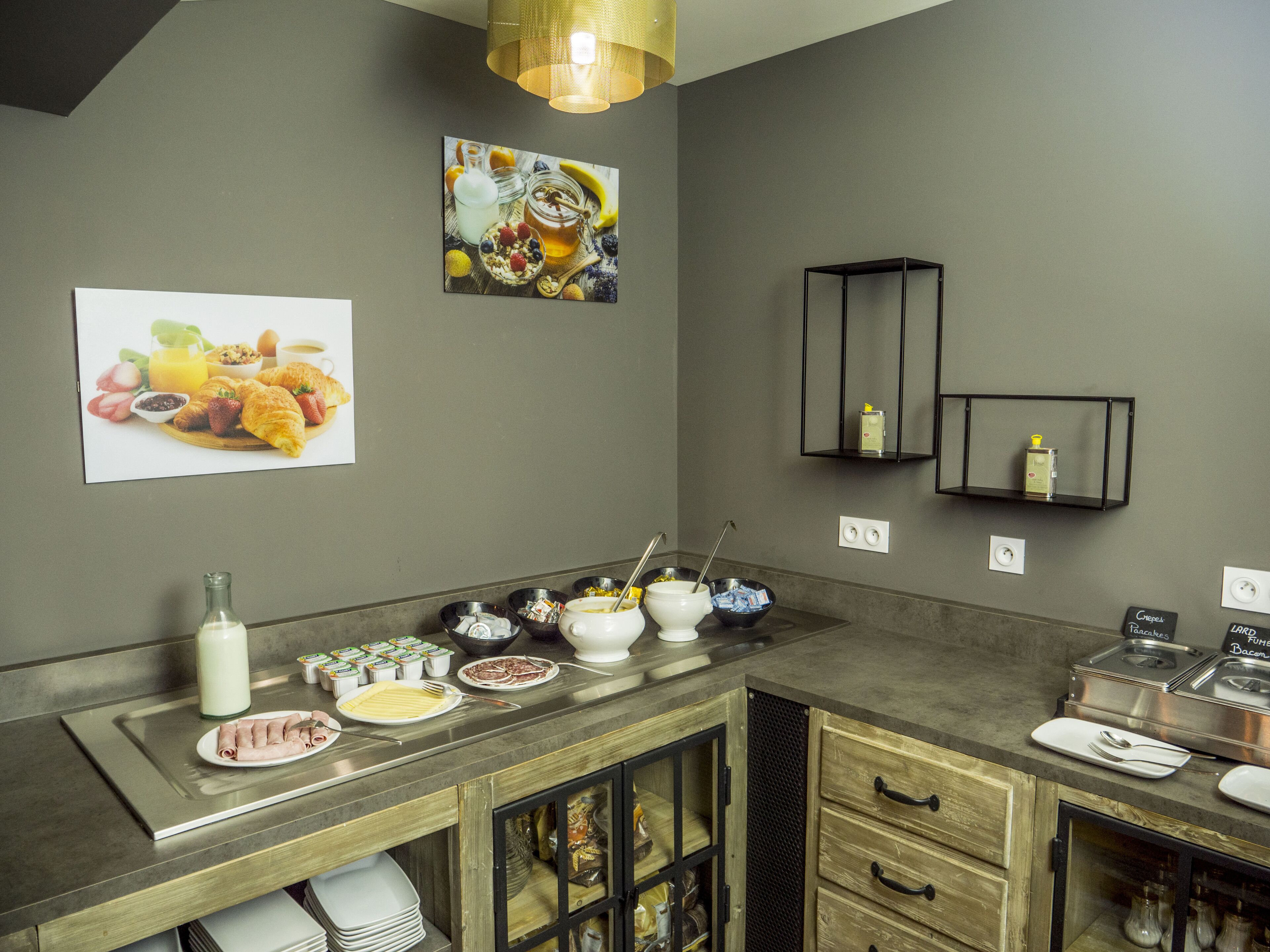 A modern kitchen with a stainless steel countertop, wooden cabinets, and a built-in oven. There are various food items and utensils on the counter.