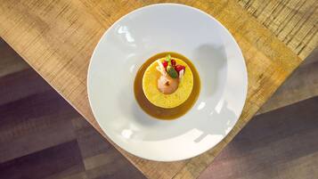 A white plate with a dessert on a wooden table.