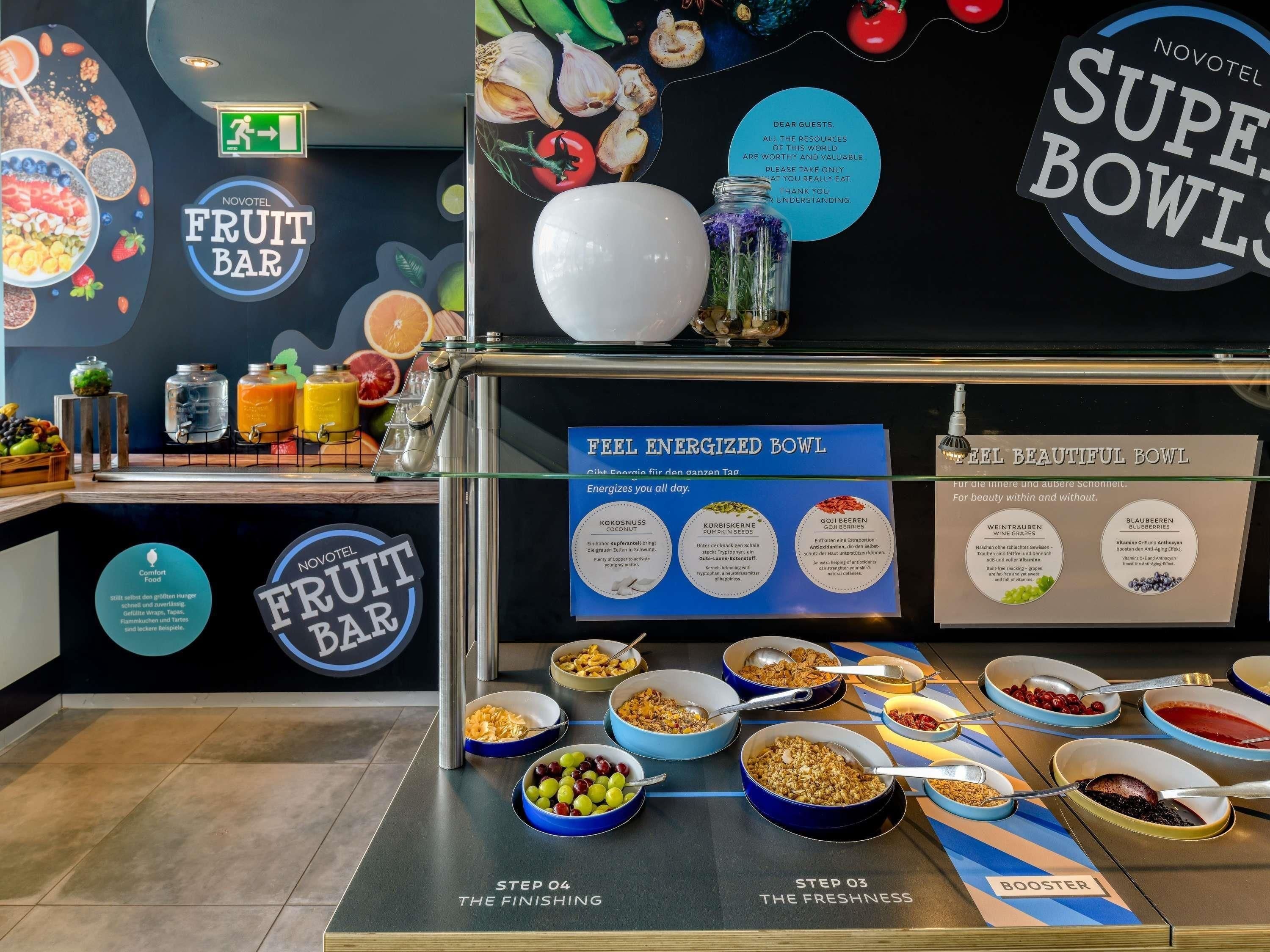 A fruit bar with various bowls of fruits and a sign indicating steps to the finishing and freshness.
