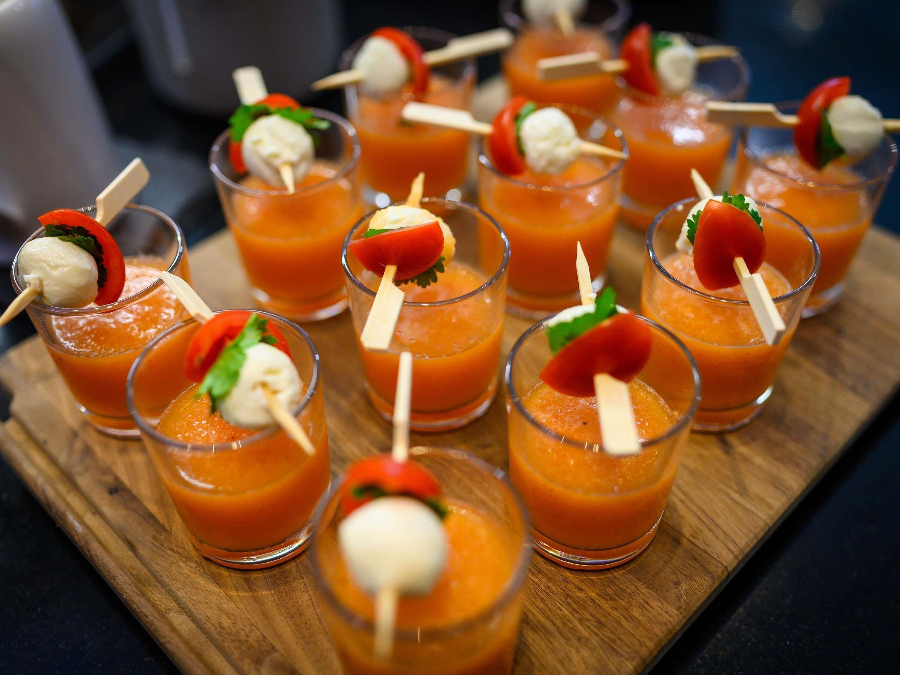 A tray of drinks with garnishes and skewers.