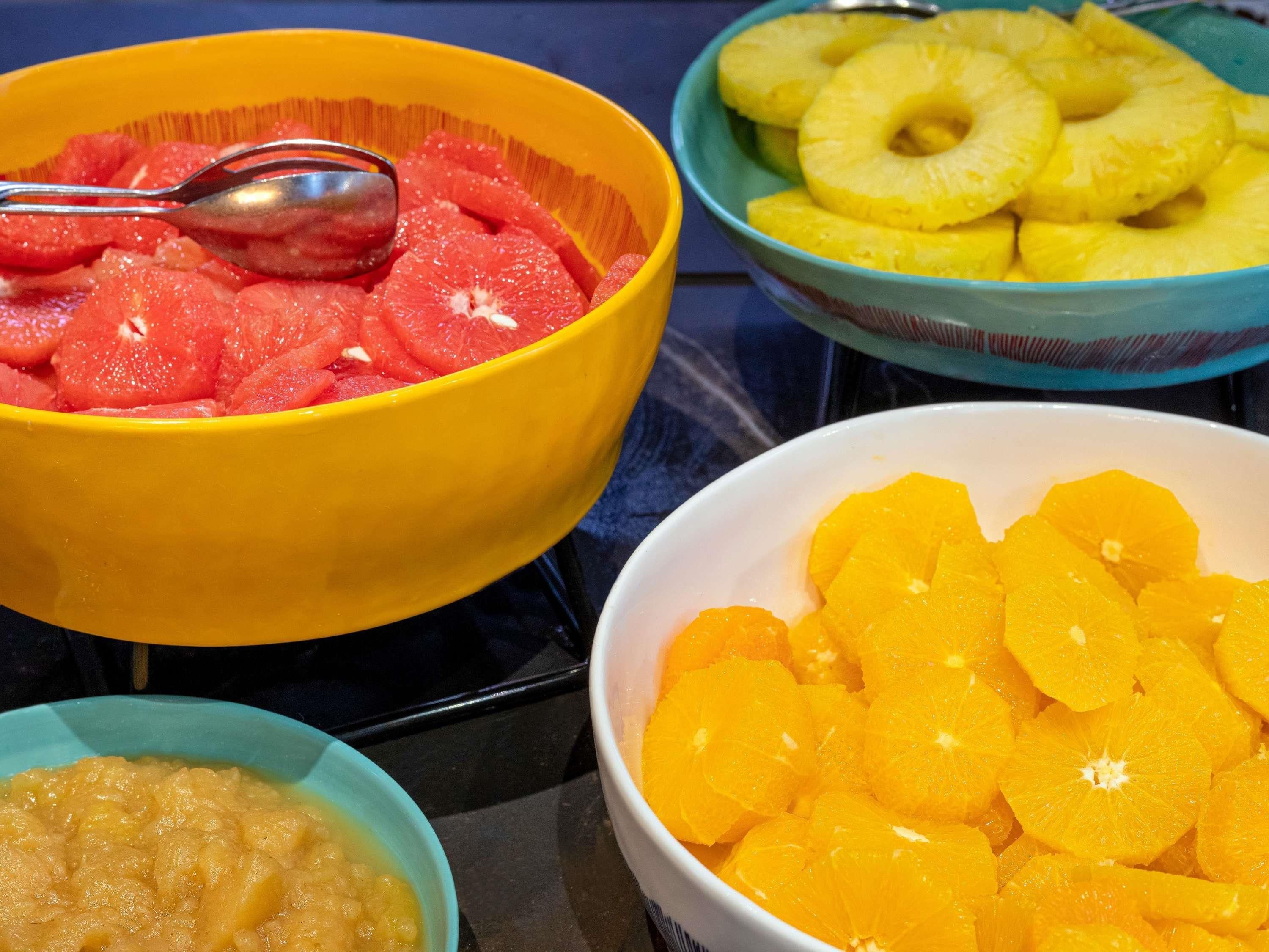 Cuatro cuencos con fruta sobre una mesa.