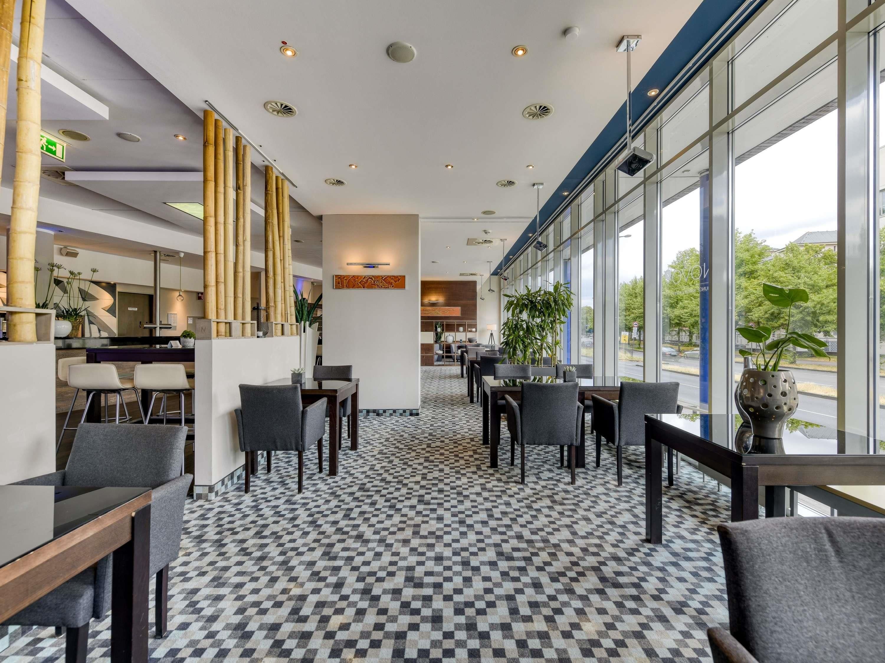 Un moderno vestíbulo de hotel con piso de diseño cuadros, una recepción y áreas de estar.