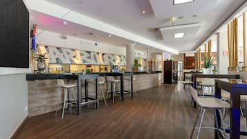 Un espace bar moderne avec un comptoir, des tabourets de bar et une enseigne indiquant « NOVO Lounge Bar & Eatery ».