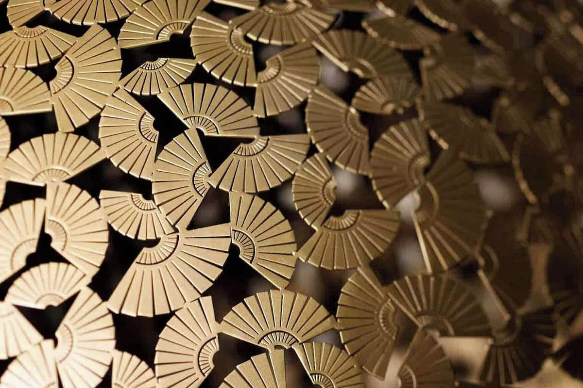 A close-up of a patterned metallic surface with a repeating geometric design.