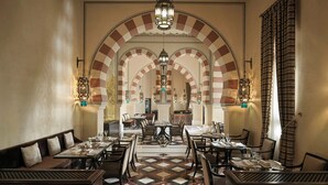Ein Restaurant mit Schachbrettboden, Gewölbedecke und traditioneller Einrichtung.