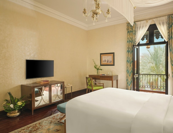 A hotel room with a bed, a desk, a chair, a television, and a window with curtains. - Old Cataract, Aswan (Aswan)
