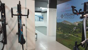 Une salle décorée sur le thème du cyclisme, avec des vélos accrochés au mur, une affiche faisant la promotion d’un séminaire sur le cyclisme et une vue sur un paysage montagneux.