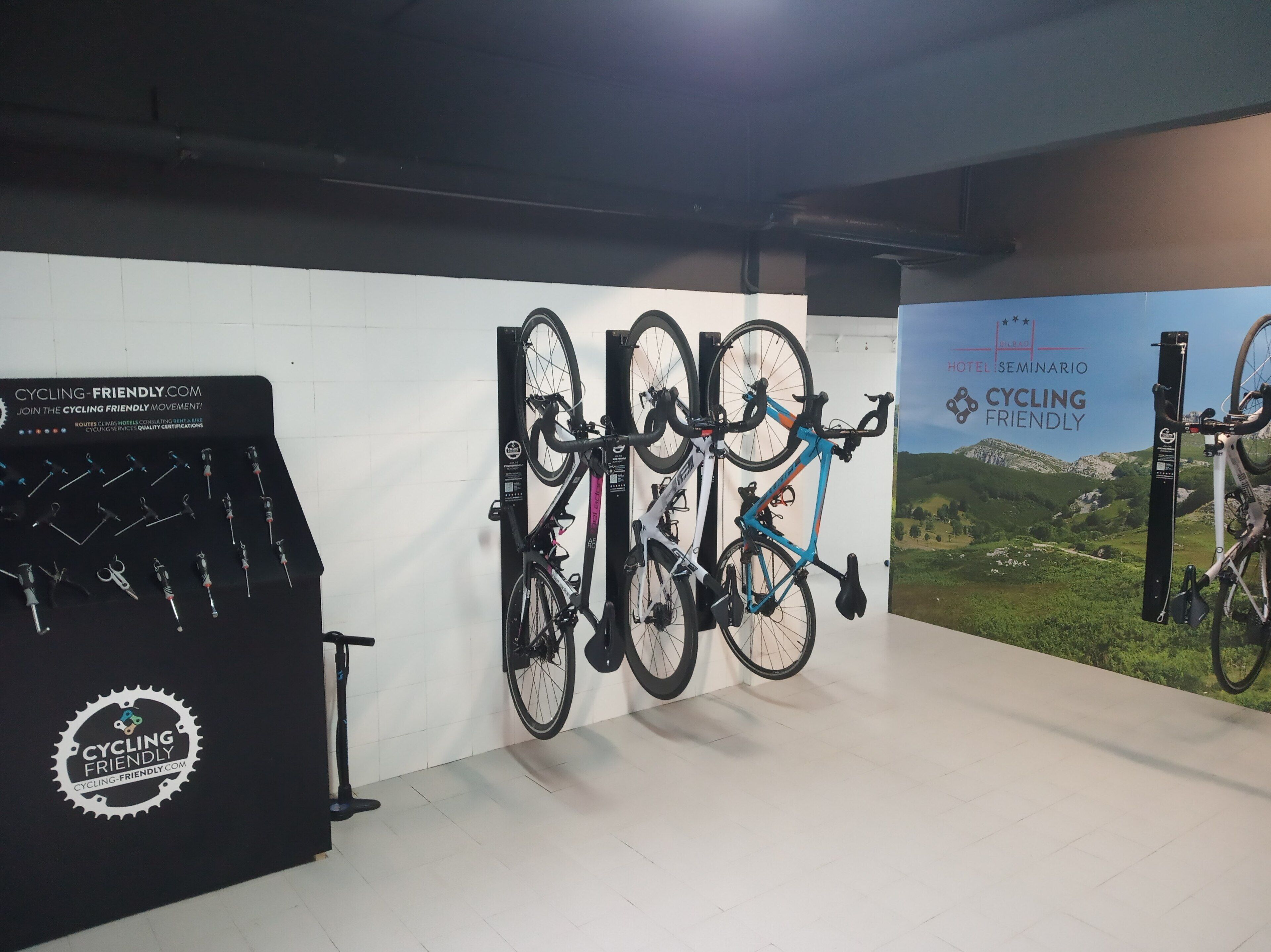 Quarto com tema de ciclismo, com bicicletas fixadas na parede e exposição de equipamentos.