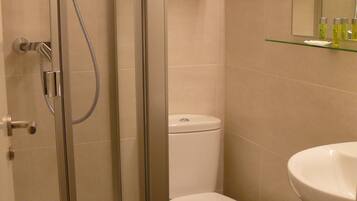 Ein Badezimmer mit einer Duschkabine, einer Toilette und einem Waschbecken.