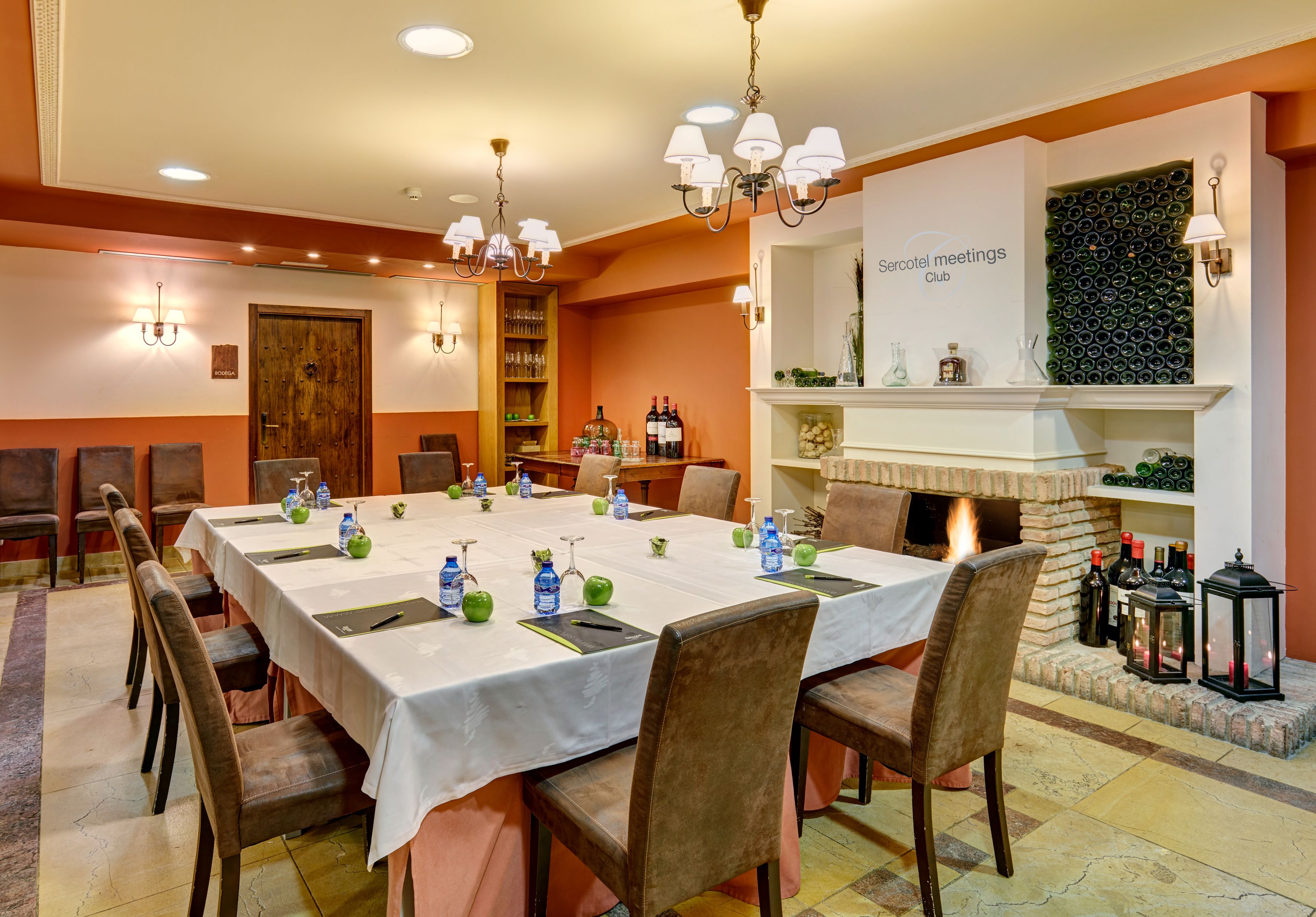 A conference room with a long table, chairs, and a fireplace.