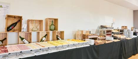 A buffet setup with various food items and wine bottles in wooden boxes.