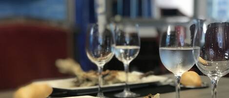 A dining table with plates of food and wine glasses.