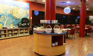A restaurant with a central counter displaying baskets and a cityscape mural on the wall. - Hotel Palacio del Mar (Santander)
